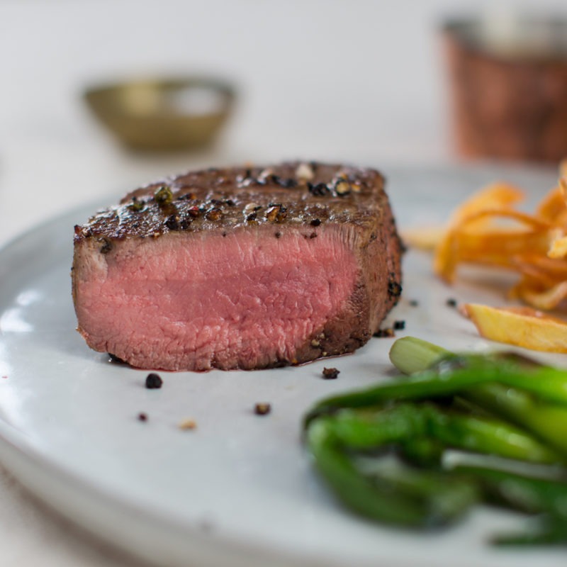 Steak au poivre with sautéed potatoes and roasted baby leeks