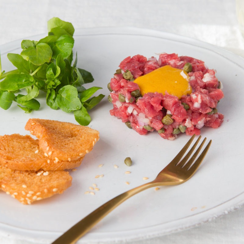Steak tartare with melba toast and watercress